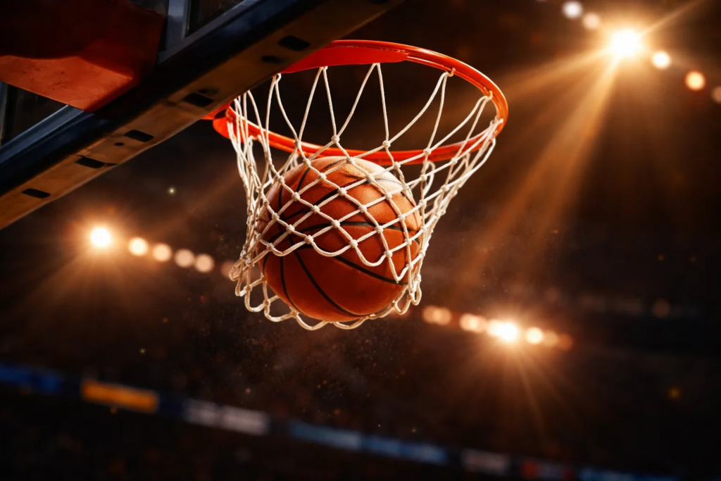 Basketball going through hoop during NBA game with arena lights
